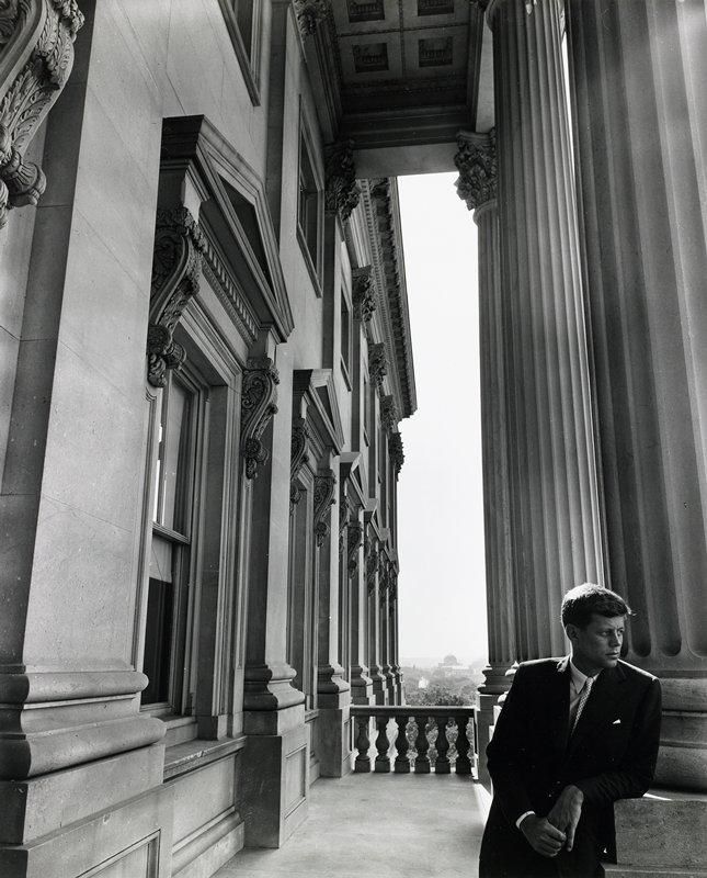 A black-and-white photograph of a young politician among Capitol columns, 1947