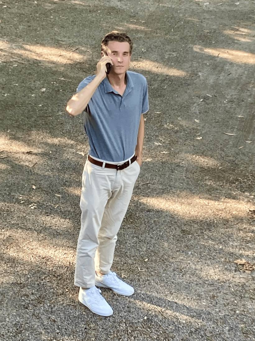 The candidate standing in a park, making a phone call while looking at the camera
